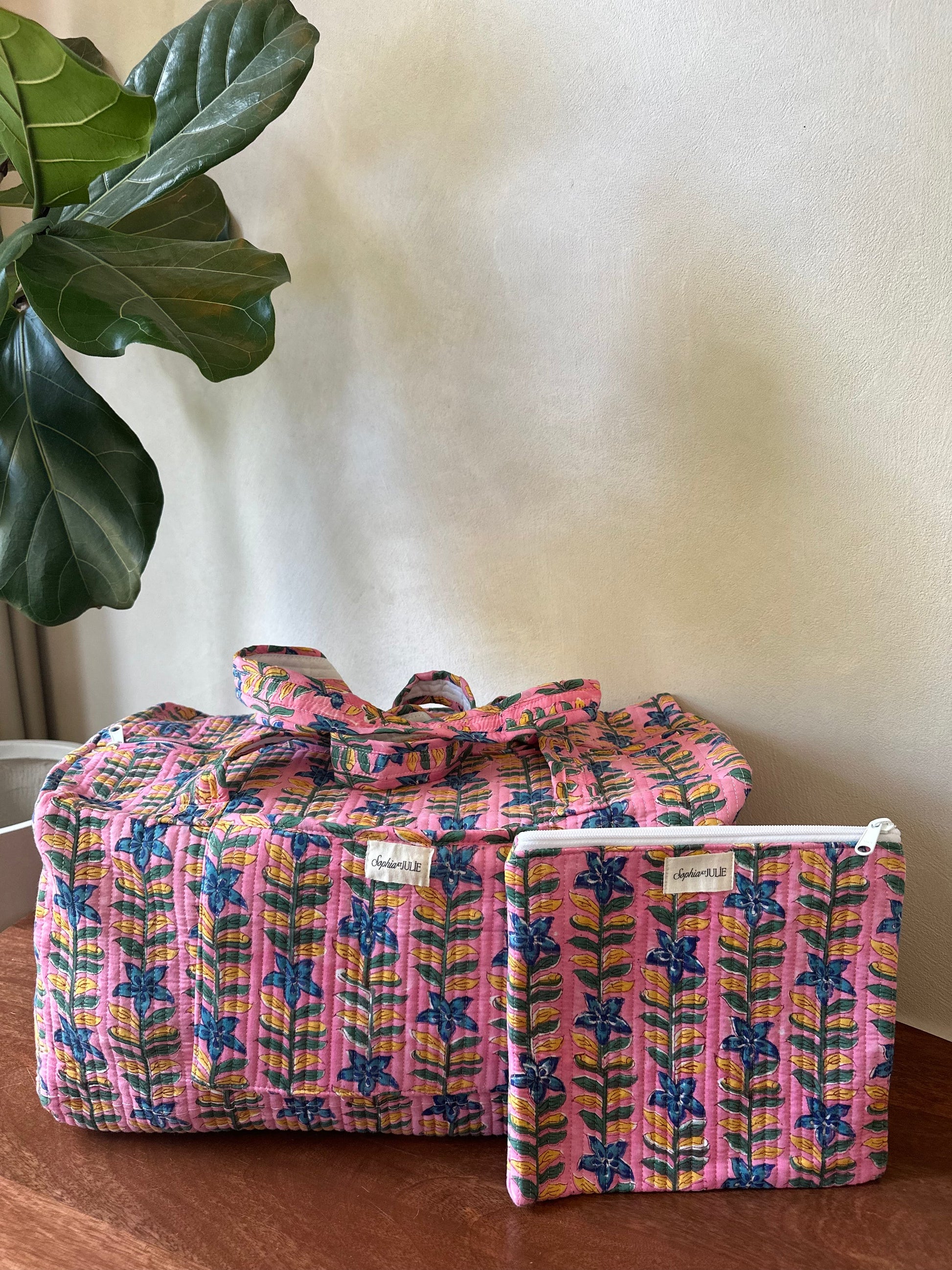 Weekendtas en platte toilettas in roze met verticale blauwe bloemstrepen